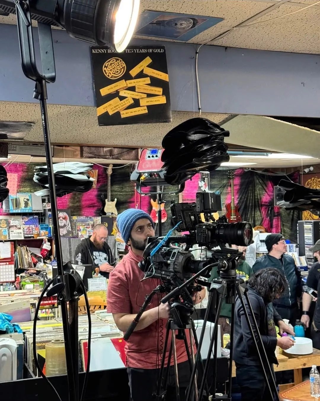 Camera operator filming inside a record store production setup